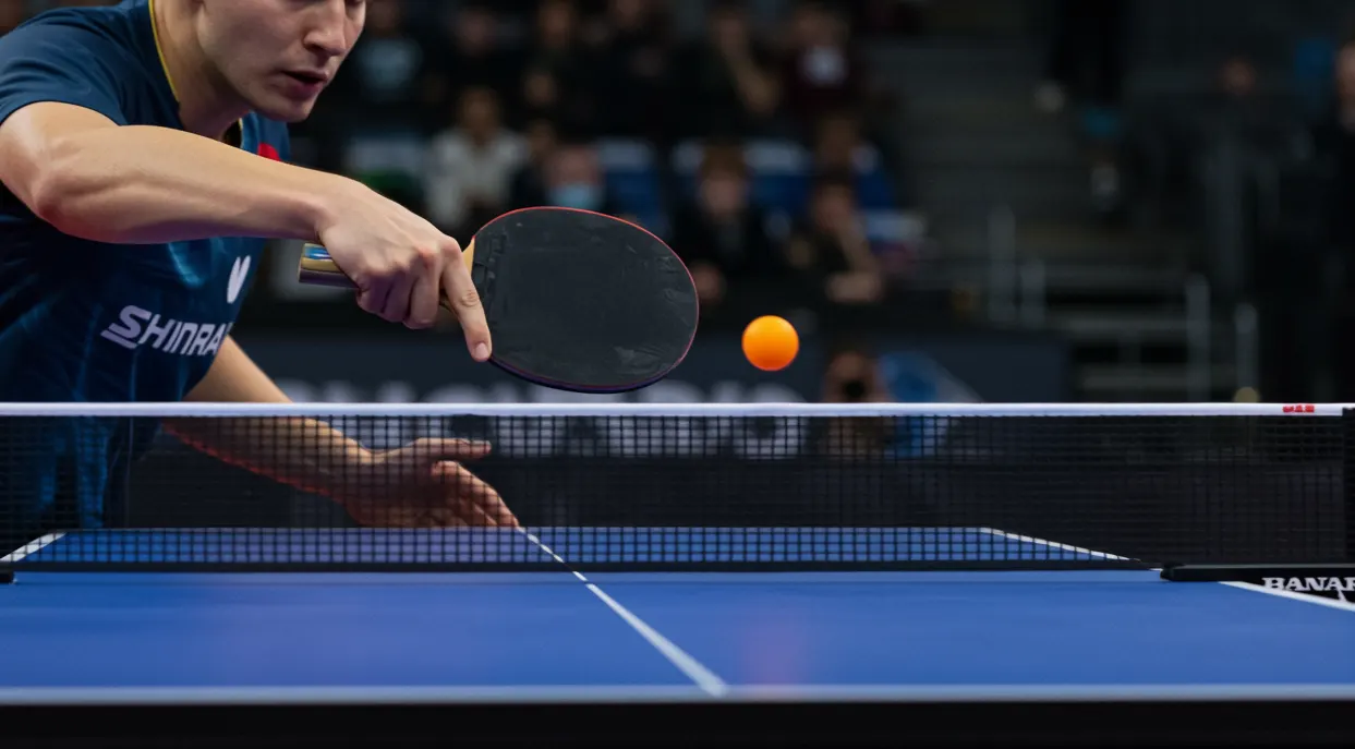 Match professionnel de tennis de table avec joueur en action pres de la table