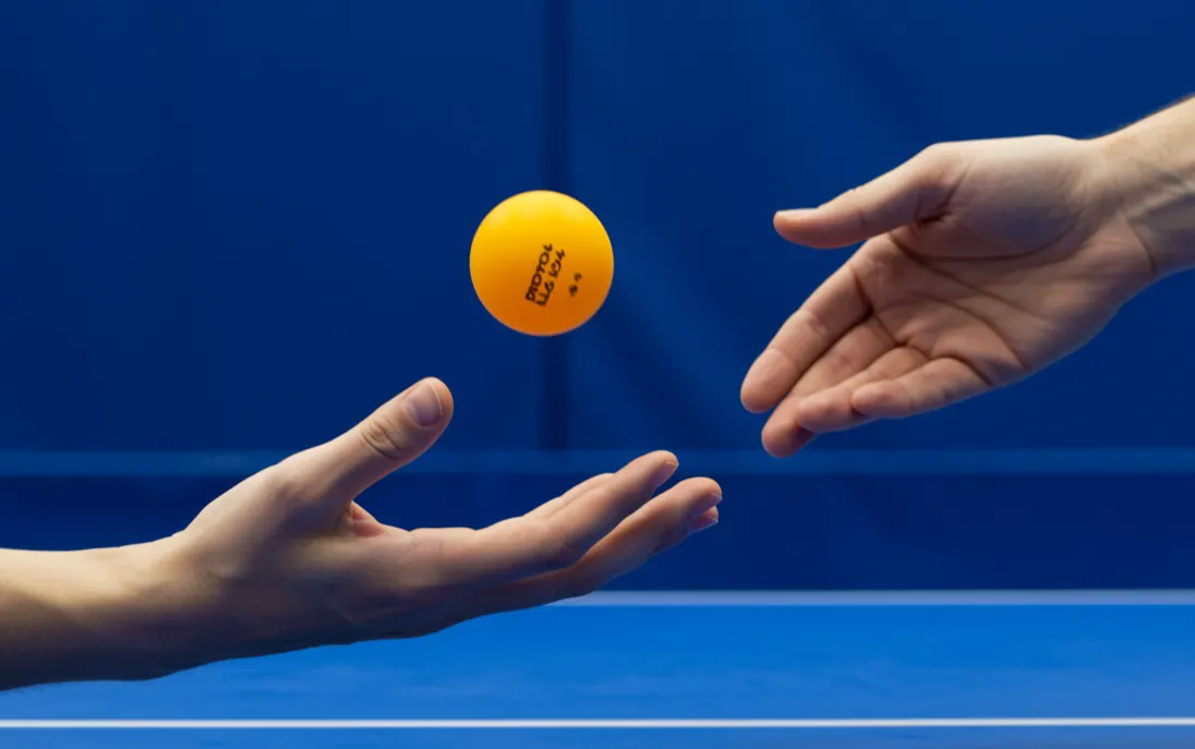 Joueur de tennis de table exécutant un service avec la balle en l'air